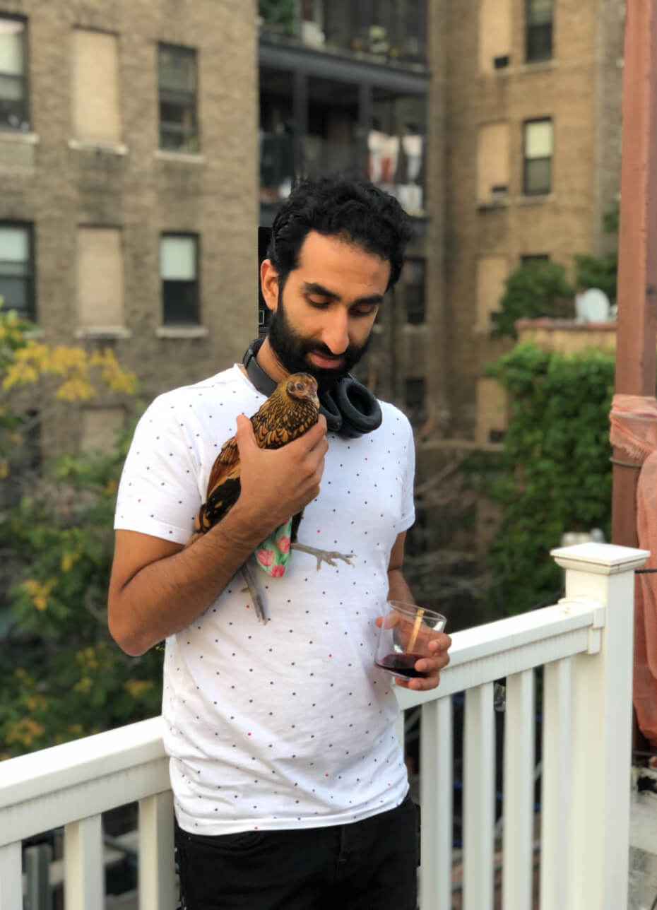 A man holding a bird on a balcony.