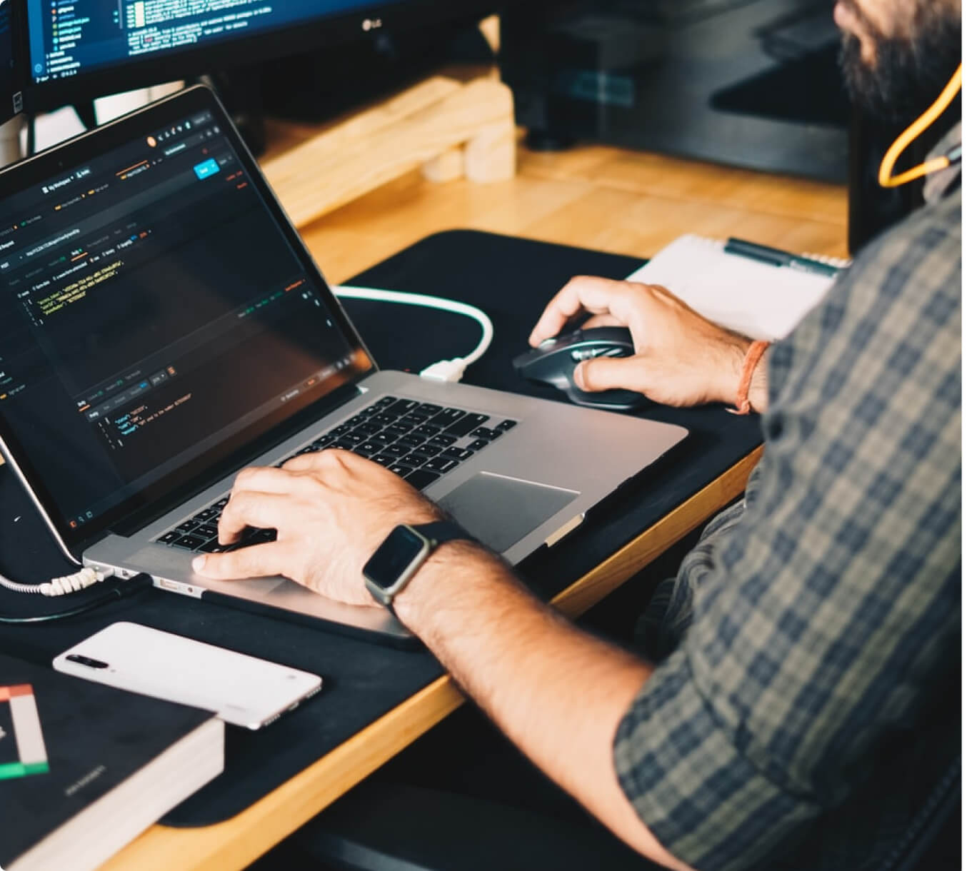 A man working on a laptop at a desk, focusing on SEO optimization for BigCommerce.
