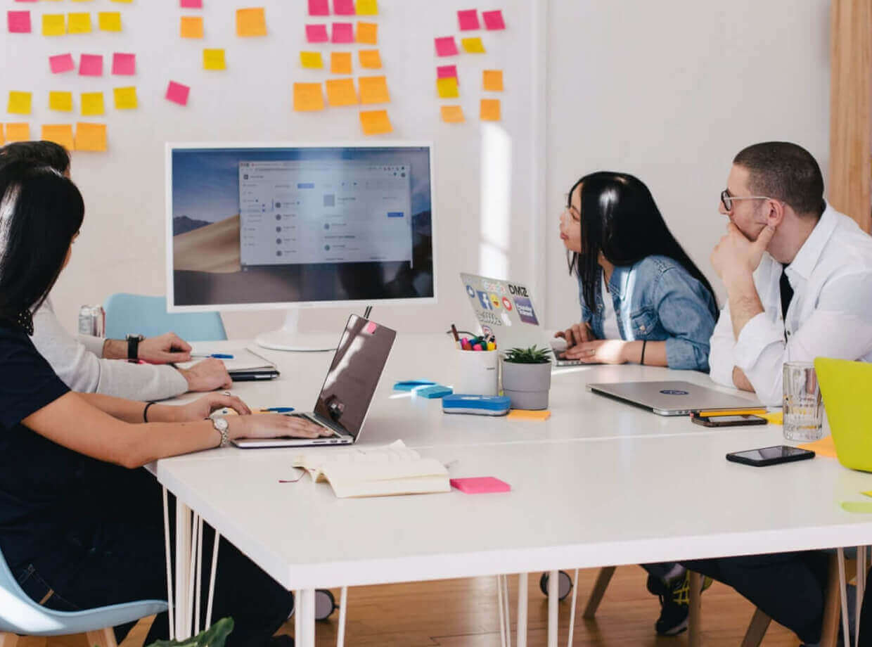 a group of coworkers looking at a desktop