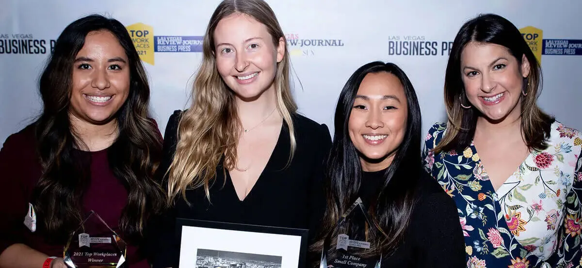 A group of women posing for a photo with an award at Top Workplaces in Nevada.