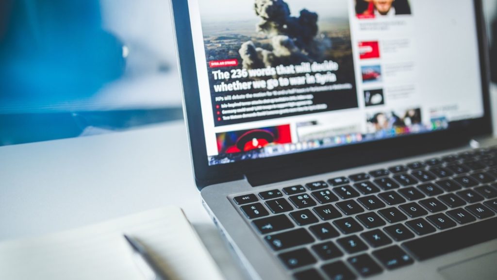 A laptop screen displaying a news article, symbolizing the power of quality link building through reputable publications.