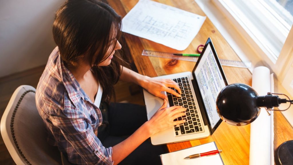 Person typing on a laptop, researching quality link building strategies for boosting website SEO and increasing organic traffic