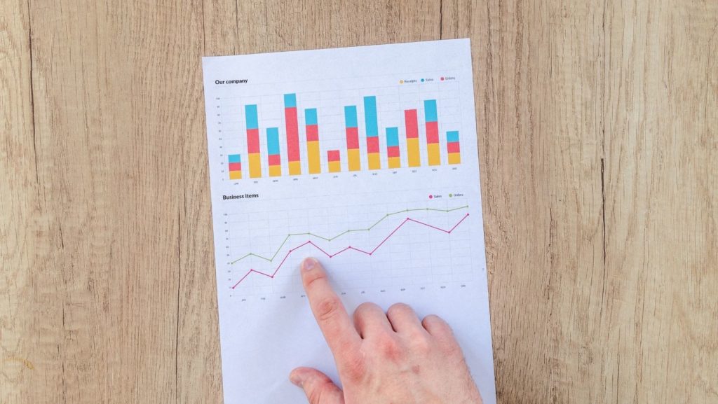 A hand pointing at a graph showing data trends, illustrating the performance tracking of a quality backlink service through measurable results.