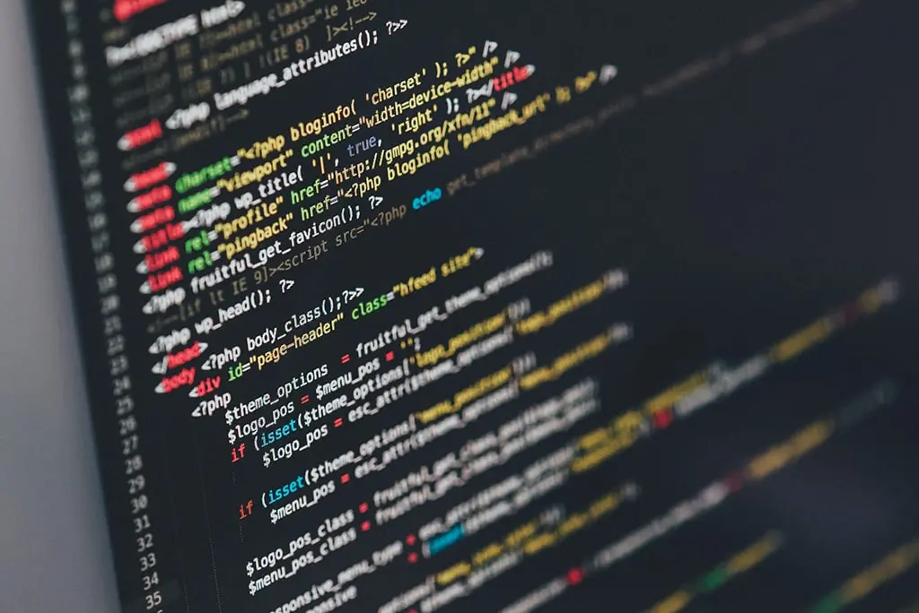 Close-up view of computer screen displaying colorful PHP and HTML code in a text editor on dark background.