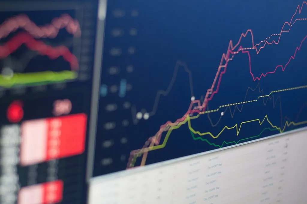 Close-up of a computer screen displaying colorful financial graphs and stock market data.