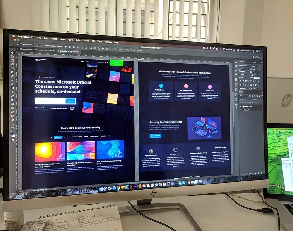 Computer monitor displaying a website layout being designed in Adobe Photoshop CC, featuring a Microsoft course platform interface with a dark-themed UI and colorful graphics.