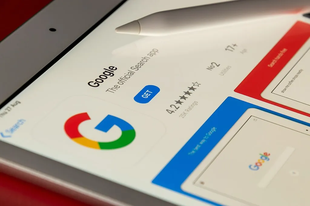 Close-up of a tablet screen displaying the Google app page on the App Store with the "GET" button and app rating