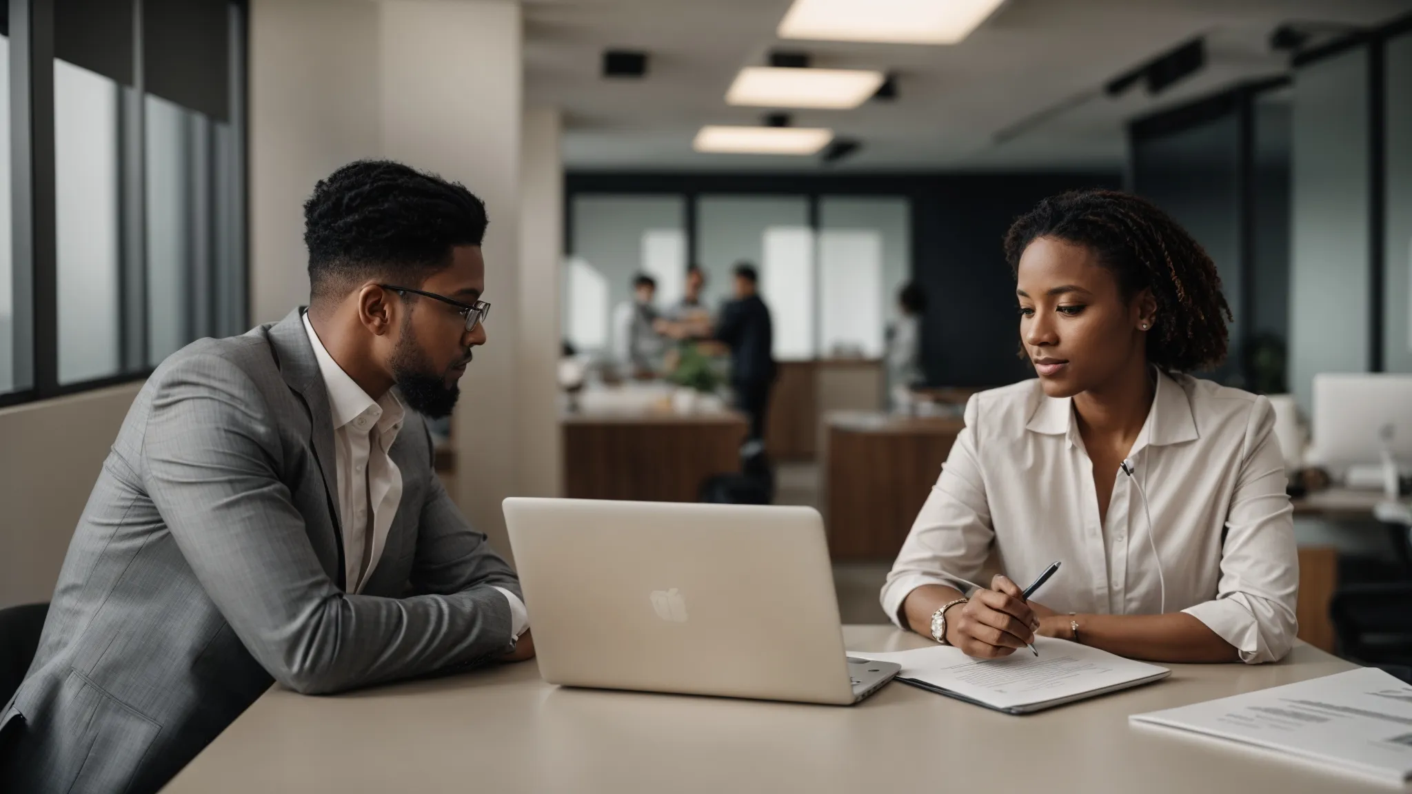 two professionals in a modern office, one holding a resume, engaged in a serious discussion during a job interview.