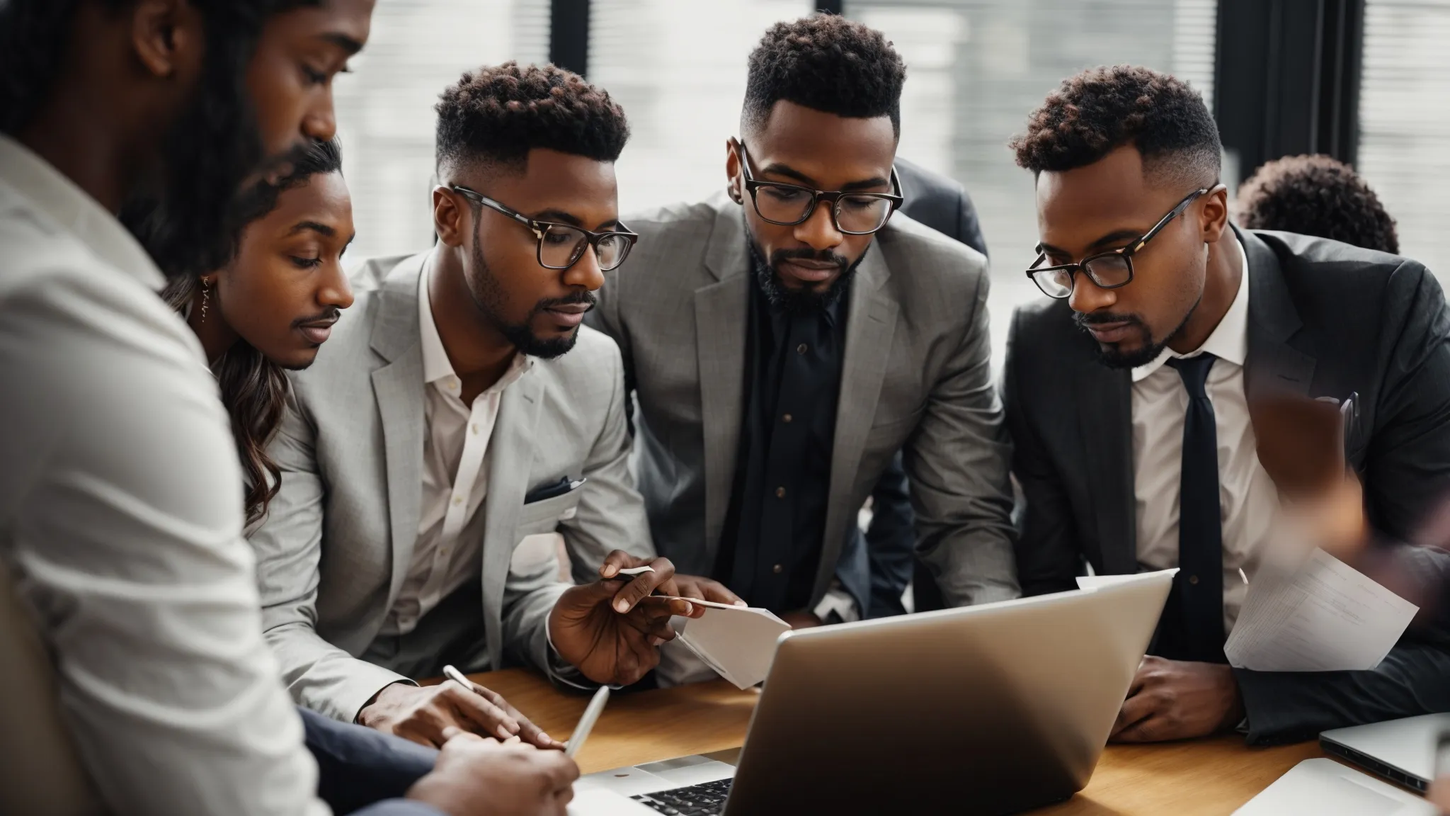 a diverse group of business professionals gather around a laptop, discussing a graph highlighting website traffic growth.