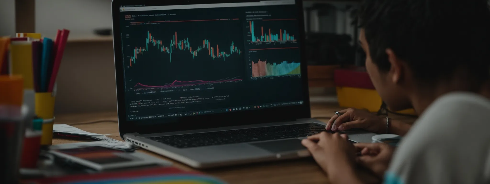 a student sits at a desk with a laptop displaying colorful graphs, engaged in an online digital marketing workshop.