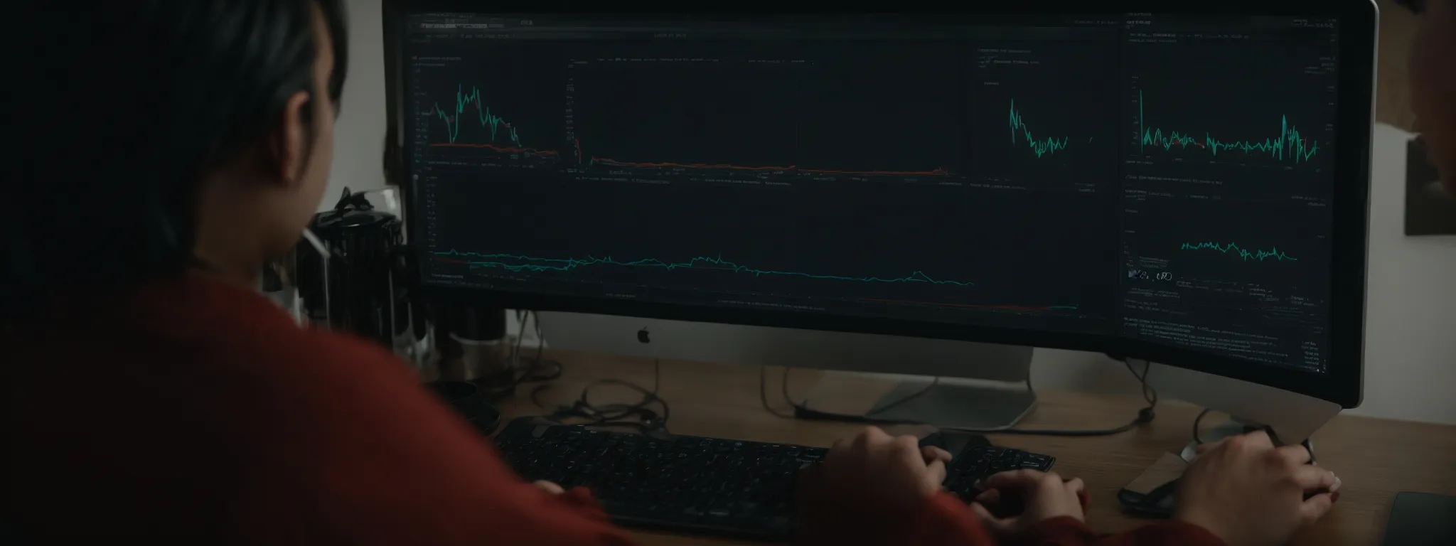 a person is sitting at a computer screen showing a rising graph indicating improved website traffic due to successful seo strategies.