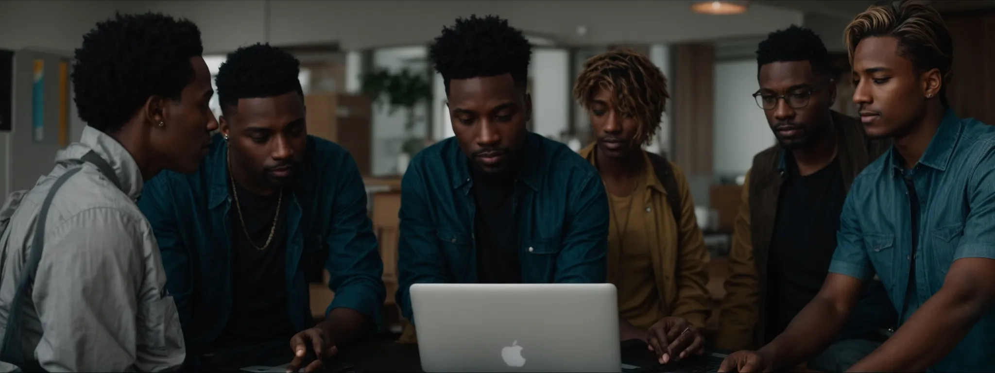 a diverse group of professionals is gathered around a laptop, collaborating on a digital document.