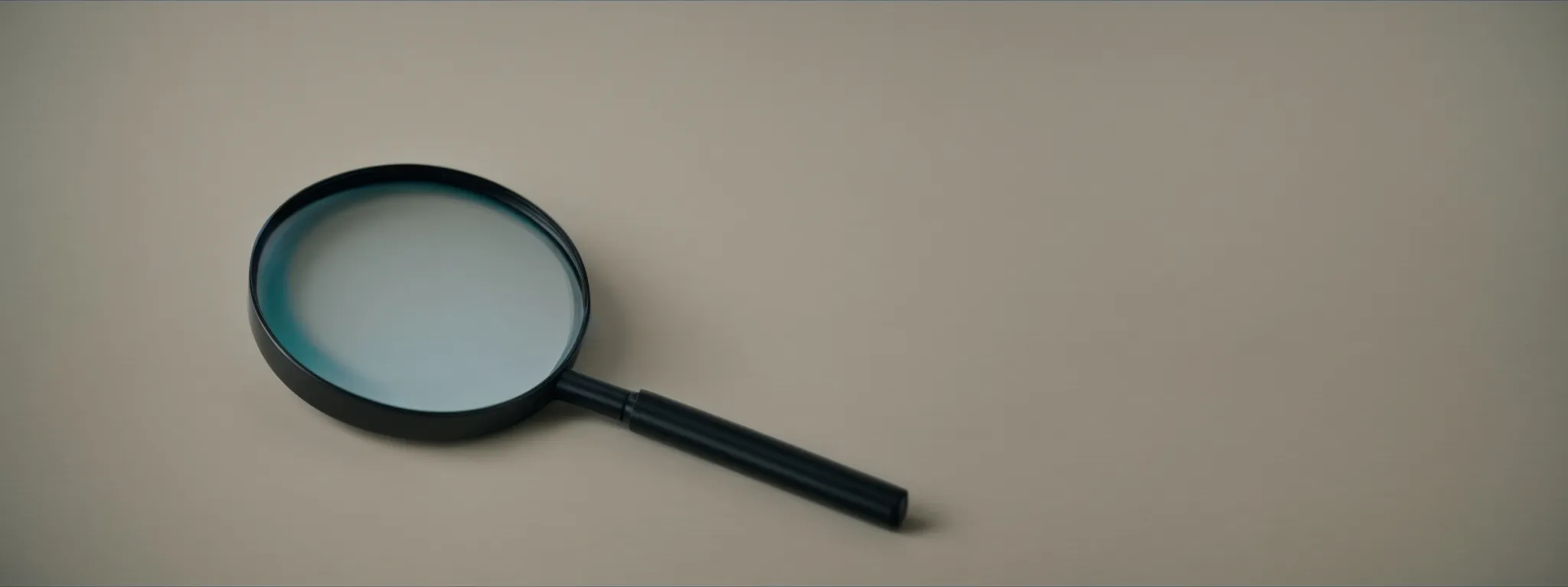 a keyboard and a magnifying glass on a desk symbolize meticulous seo research on long-tail keywords.