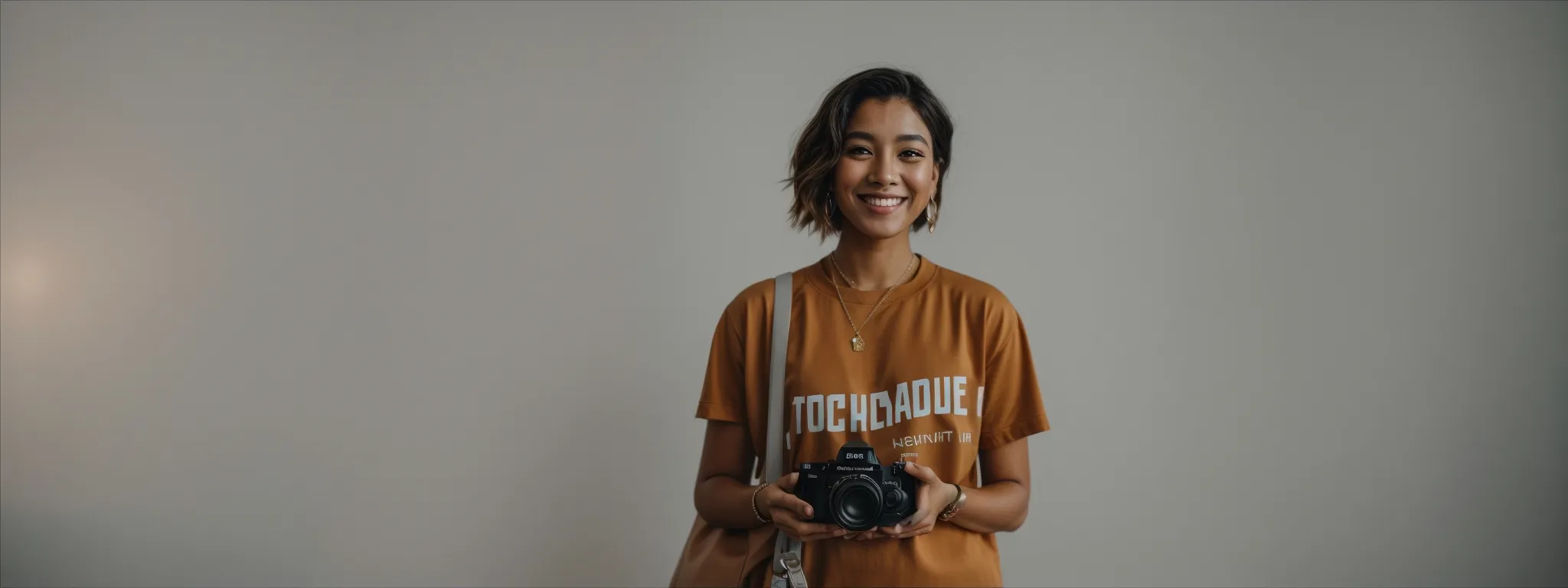 an influencer holding a product with an engaging smile, standing before a plain background, poised to discuss its features.