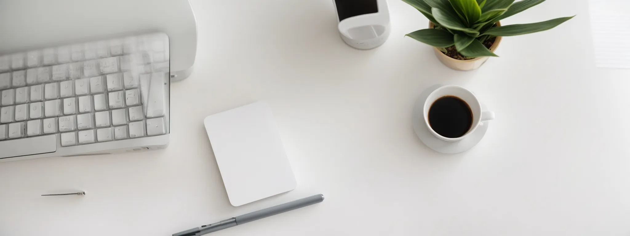 a keyboard, computer, and notepad on a minimalist desk with a plant symbolizing an organized freelance seo consultant's workspace.