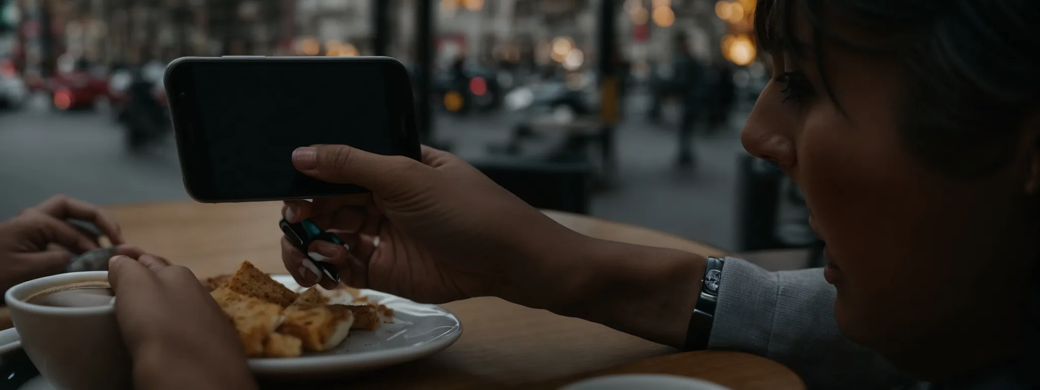 a person reading reviews on a smartphone while sitting at a cafe table with a cup of coffee.