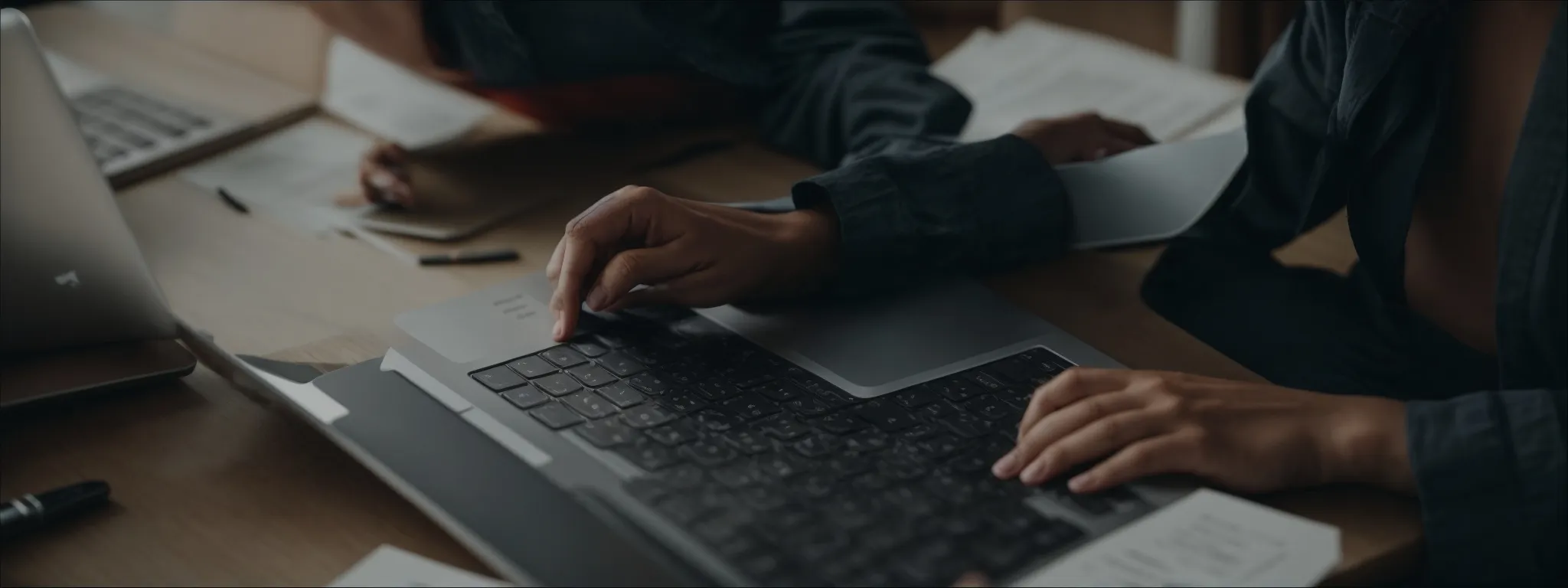 a person typing on a laptop surrounded by marketing analytics charts.