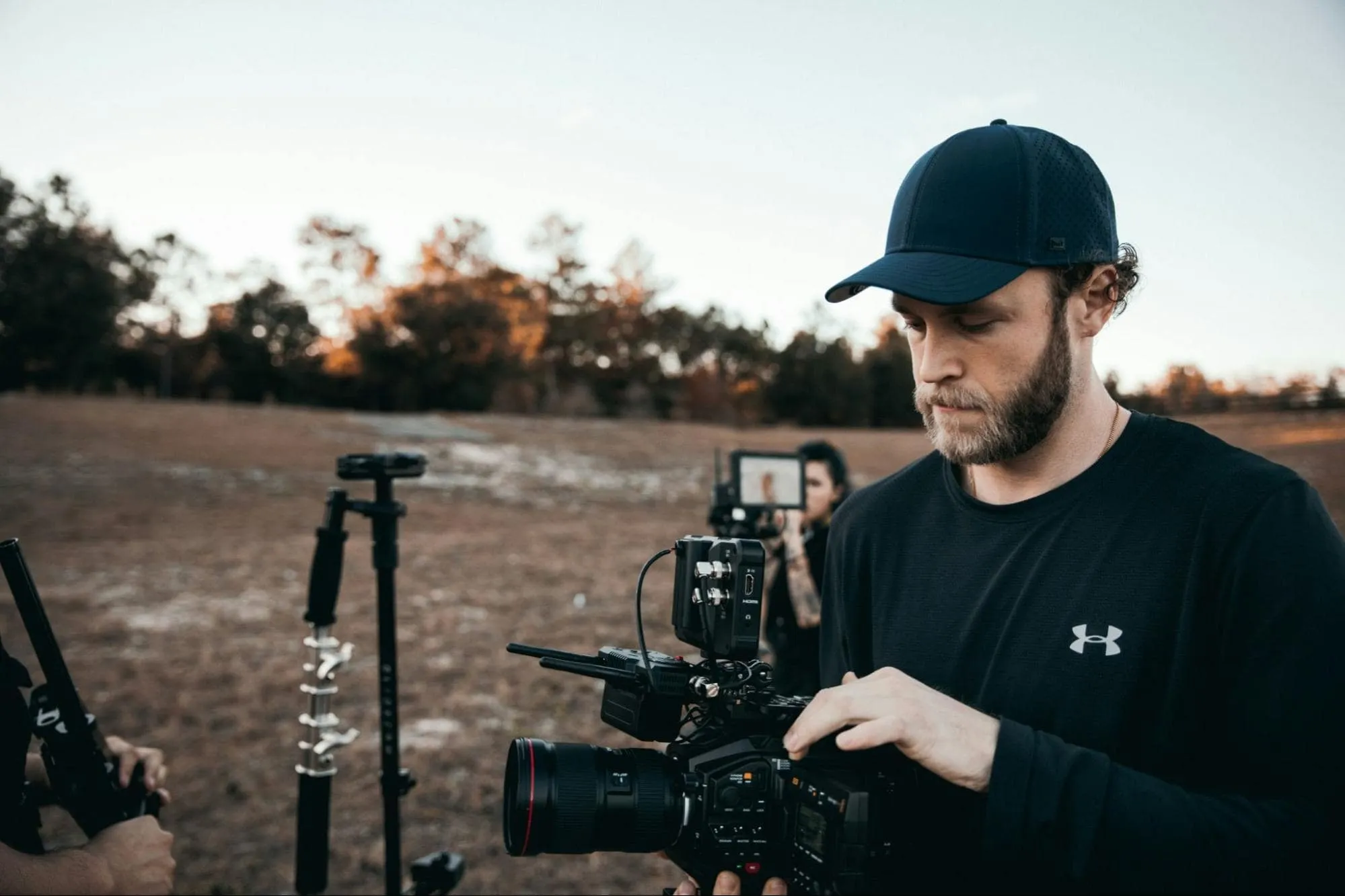 Photographer adjusting a camera outdoors, representing the importance of SEO services for photographers to increase visibility and attract clients